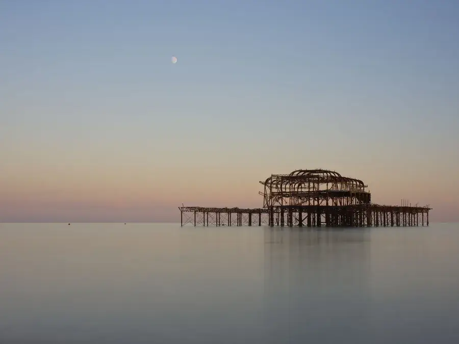 The remains of Brighton West Pier at dusk, seen from the seafront The remains of Brighton West Pier at dusk, seen from the seafront